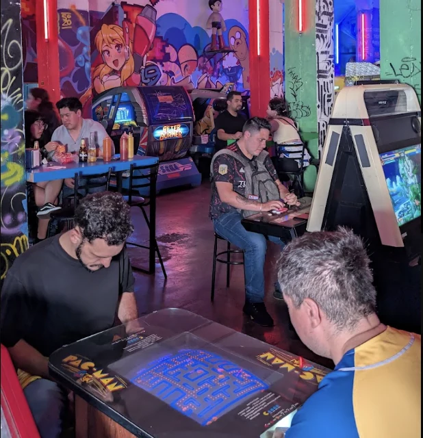 Personas jugando en máquinas de arcade